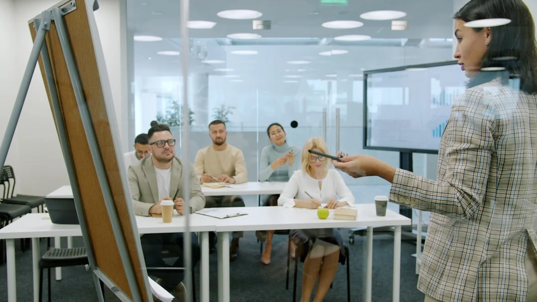 Two businessmen analyze stock market data using a smartphone and laptop in a modern office setting.
